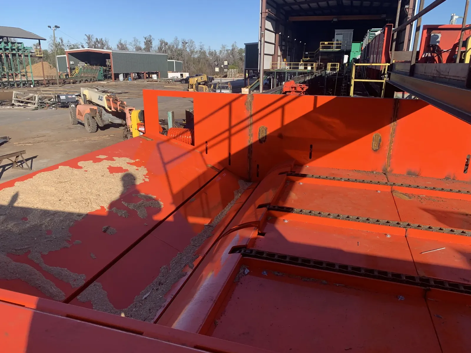 Log pusher placing logs on a transverse deck