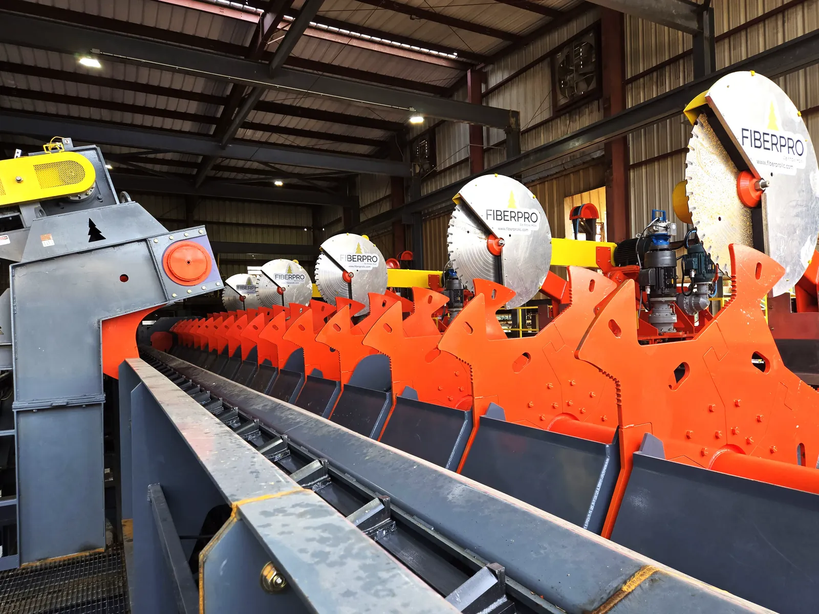 FiberPro saw blades mounted above the V-flight scan chain on the Gen 7 log trimmer line